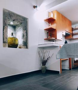 a kitchen with a vase sitting on the wall at Casa do Beco in Angra do Heroísmo +13 photos