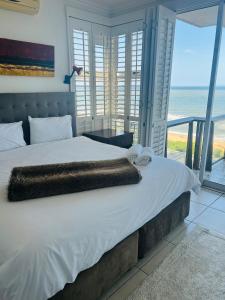 a bedroom with a bed with a view of the ocean at Seaviews Queen in Westbrook