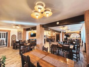 a dining room with wooden tables and chairs at Pensiunea Bella Vista in Arefu