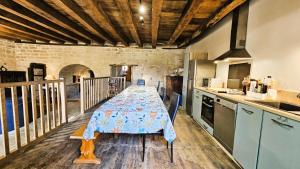 a kitchen with a table with a table cloth on it at Gîte de France Des alpagas 2 épis - Gîte de France 12 personnes MAE-9944 in Chaumeil +35 photos
