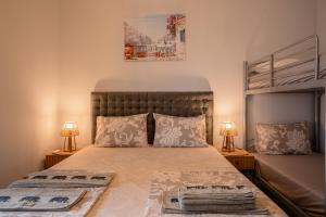 a bedroom with a large bed with two lamps at Nero Blu by the Sea in Nea Kalikratia