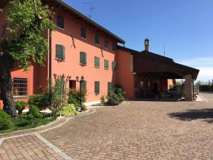 a large orange building with a brick driveway at Isola Di Wight in San Michele al Tagliamento