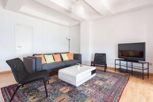 un soggiorno con divano e TV di Apartamentos Bahía Alicante ad Alicante
