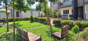 two benches sitting in the grass in a garden at Oreville Apartments in Goma
