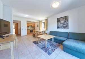 sala de estar con sofá azul y mesa en Life & Luxury Appartements, en Saalbach Hinterglemm