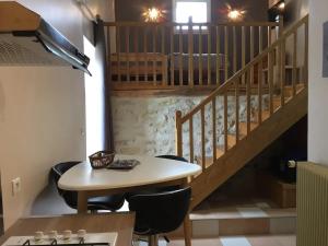 ein Esszimmer mit einem Tisch und einer Treppe in der Unterkunft Charmante maison avec piscine à Chalandray, 25 m² in Chalandray
