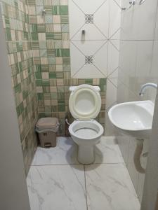 a bathroom with a toilet and a sink at Pousada Cajueiro in Juazeiro do Norte