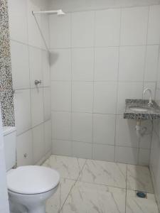 a white bathroom with a toilet and a sink at Pousada Cajueiro in Juazeiro do Norte +20 photos