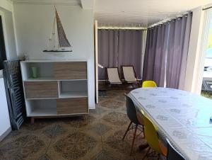 a room with a table and chairs and a dresser at lebonair in Salazie