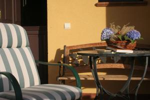 una mesa con un jarrón de flores y una silla en Apartamentos Rurales Obaya, en Villaviciosa