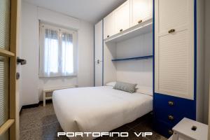 a bedroom with a white bed and a blue door at Cocca's House by PortofinoVip in Portofino