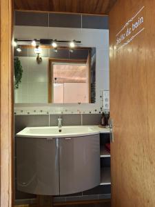 une salle de bain avec un lavabo et un miroir dans l'établissement Maison de Bourg, à Rochefort-Montagne