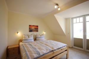 a bedroom with a bed with two pillows on it at Achtern Diek - Ferienwohnungen in Börgerende-Rethwisch