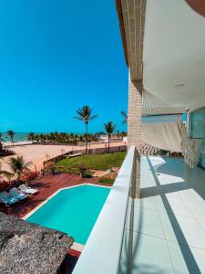 a view of a swimming pool and the beach at Mansão do Kite - Praia do Coqueiro in Luis Correia