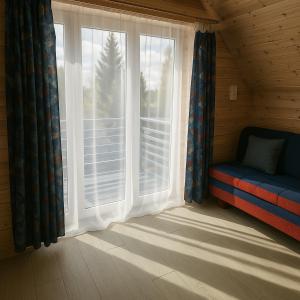 a window in a room with a couch next to a window at Apartamentai in Veisiejai +8 photos