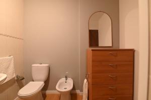 ein Badezimmer mit Toilette, Waschbecken und Spiegel in der Unterkunft Lagoa Sea View by Vacationy in Lagoa + 36 Fotos