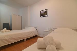 ein weißes Schlafzimmer mit zwei Betten und einem Schrank in der Unterkunft Lagoa Sea View by Vacationy in Lagoa