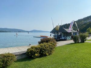 a dock on a lake with a boat house at Ferienwohnung Carlotta - Kärnten Wörthersee in Reifnitz