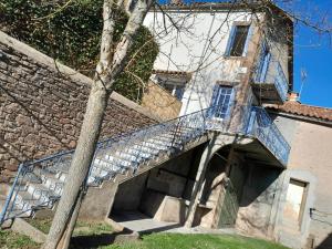 a staircase leading up to a building with a tree at Gîte Bienvenue chez vous in Belmont-sur-Rance