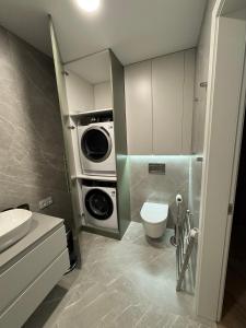 Un baño con lavadora y un inodoro. en Modern Luxury Apartment in Old Town, en Klaipėda