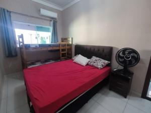 a bedroom with a bed with a red blanket and a window at Casa Com Piscina Aquecida in Caldas Novas +34 photos