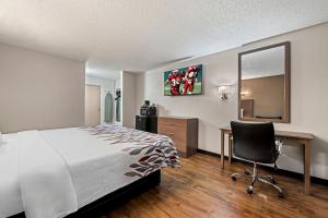 a bedroom with a bed and a desk and a chair at Red Roof Inn Charlotte - University in Charlotte +21 photos