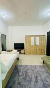 a bedroom with two beds and a flat screen tv at River & Sky Homes 6004 in Abu Dhabi