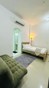 a white bedroom with a bed and a rug at River & Sky Homes 6004 in Abu Dhabi
