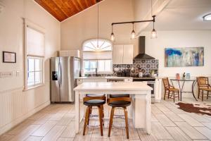 Una cocina con encimera blanca y refrigerador. en Gardens of Barons Creek - UNIT C, en Fredericksburg