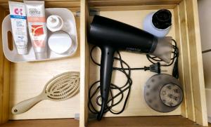 a blow dryer and other kitchen items in a drawer at Saulė in Anykščiai