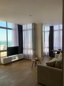 a living room with a couch and a flat screen tv at Blue Nest Luxury Apartments in Durrës