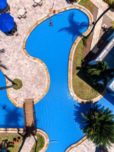 an overhead view of a swimming pool with palm trees at Baía Branca Beach Resort in Tamandaré