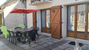 a patio with a table and chairs and an umbrella at Gite N 4 du Bas Coudreau in Rosnay