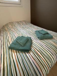 two towels sitting on top of a bed at Appartement Cosy Parking, Plage & Commerces à Deux Pas in Argelès-sur-Mer