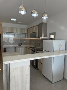 a large kitchen with a white counter top in it at Crystal al mar in Puerto Madryn