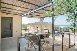 a patio with a table and chairs on a balcony at LIOSTASI luxury suites in Tragána