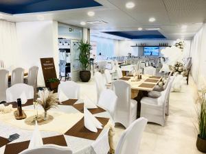 a dining room with white tables and white chairs at La Frontiera Hotel & Eventlocation - idyllisch, nah' der Schweiz - zum Rheinfall bei Schaffhausen in Tengen