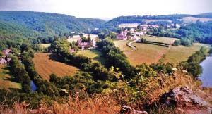 an aerial view of a town on a hill with a river at La Maison de Cure in Domecy-sur-Cure