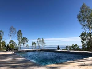 a swimming pool with the ocean in the background at Villa Les Arches in La Malbaie