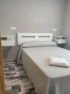 Un dormitorio con una cama blanca con una toalla encima. en Coalla Rooms Luxe, en Lugones