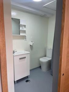 Un baño blanco con inodoro y lavabo. en Coalla Rooms Luxe, en Lugones