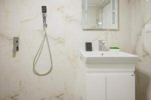 a white bathroom with a shower and a sink at Nero Blu by the Sea in Nea Kalikratia +18 photos