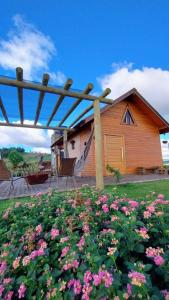 a house with a bunch of flowers in front of it at Chico Cabanas in Lajeado Grande