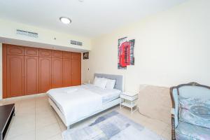 ein Schlafzimmer mit einem großen weißen Bett und einer Couch in der Unterkunft Beachfront holiday homes with beach,sauna,jacuzzi,cafe,restaurants and more in Ajman 