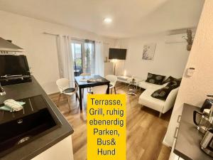 a room with a kitchen and a living room at OLIVE - Ruhe & Entspannung in 2-Zi-Fewo mit Garten-Whirlpool, Terrasse & Hund willkommen by FerienWohnenAmSee in Überlingen