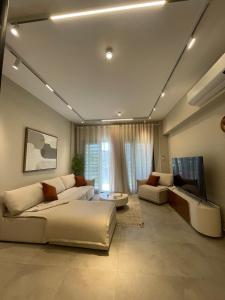 un salon avec deux canapés et une télévision dans l'établissement Nova Garden View Madinaty Retreat, à Madinaty 63 autres photos