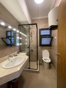 une salle de bain avec douche, lavabo et toilettes dans l'établissement Nova Garden View Madinaty Retreat, à Madinaty