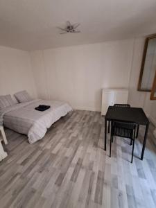 a bedroom with a bed and a table in it at budgetbnb Larmodieu 1 in Toulon