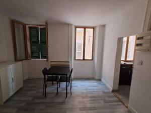 a dining room with a table and chairs and windows at budgetbnb Larmodieu 1 in Toulon