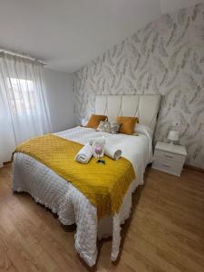 a bedroom with a large bed with a yellow blanket at Piso La Cumbre - CEE in Cee